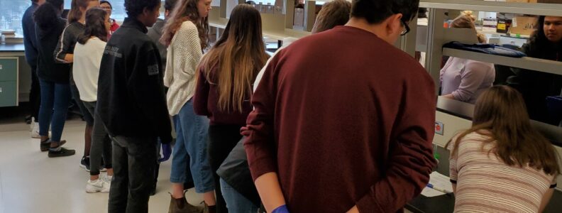 Children stand around lab bench at CHRIM.