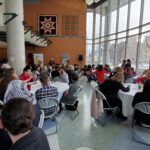 Large group of people mingle on the ground floor of the John Buhler Research Centre.