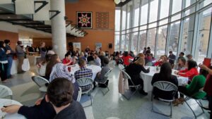 Large group of people mingle on the ground floor of the John Buhler Research Centre.