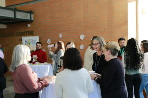 CHRIM members mingling at festive get together. Tannis Erickson is in focus laughing.