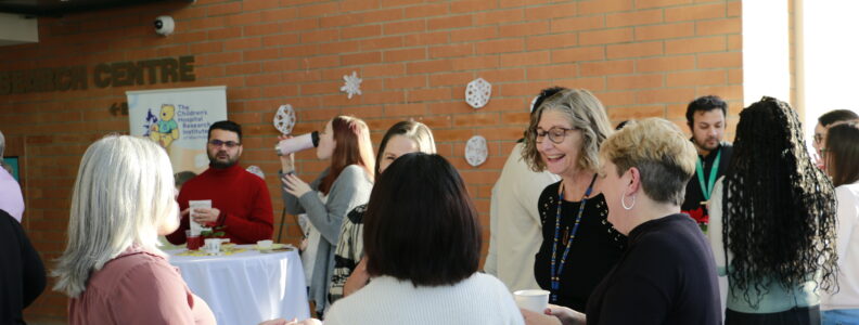 CHRIM members mingling at festive get together. Tannis Erickson is in focus laughing.